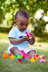 Wall Mural - Little african american baby boy playing in the grass