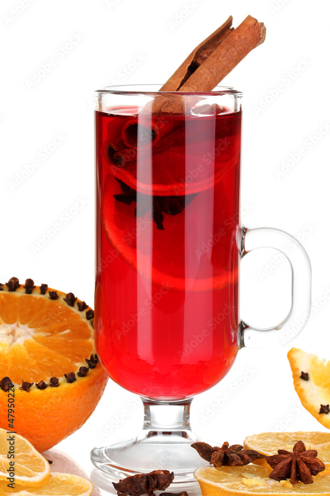 Fragrant mulled wine in glass with spices and oranges around