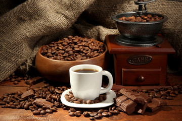 Poster - Coffee grinder and cup of coffee on burlap background