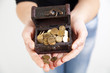 woman hands holding old antique treasure chest with gold coins