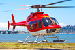 Startender Hubschrauber Bell 407 von malerischem Landeplatz