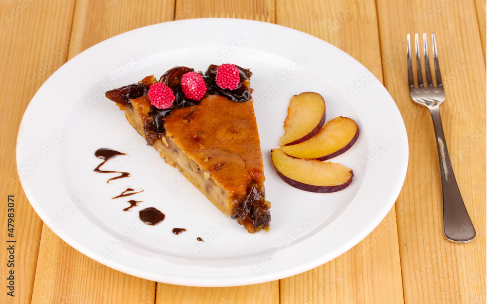 Tasty pie on plate on wooden table