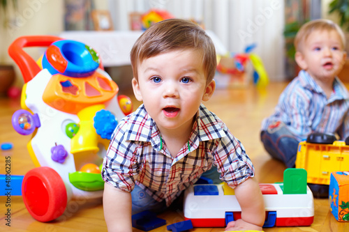 Foto Neugieriges Baby, das Baumschulenraum studiert