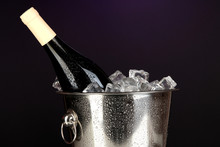 Bottle Of Wine In Ice Bucket On Darck Purple Background