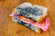 © dziewul - moldy sandwich with salami, tomatoes on a chopping board
