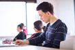 © lightpoet - young, handsome male college student sitting in a classroom