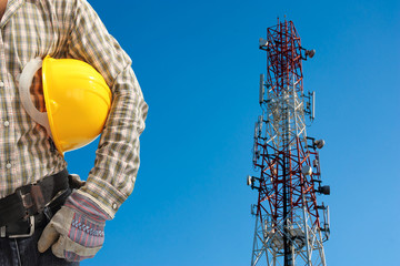 technician against telecommunication tower, painted white and re