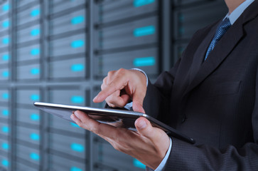 businessman using tablet computer and server room background