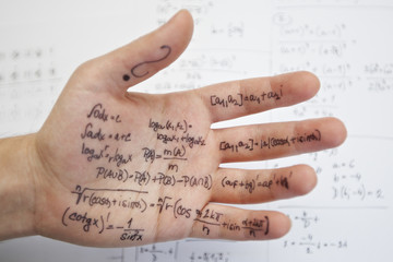 Hand of student with cheat sheet for math exam