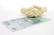Splecione dłonie nad banknotem 100 zł 