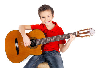 happy  boy is playing on acoustic guitar