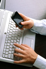 Wall Mural - Businessman using laptop and mobile phone