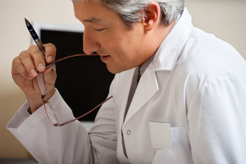 Wall Mural - Doctor Holding Pen And Glasses