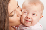 Fototapeta  - mother  kissing baby girl