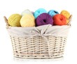 Colorful yarn balls in wicker basket isolated on white