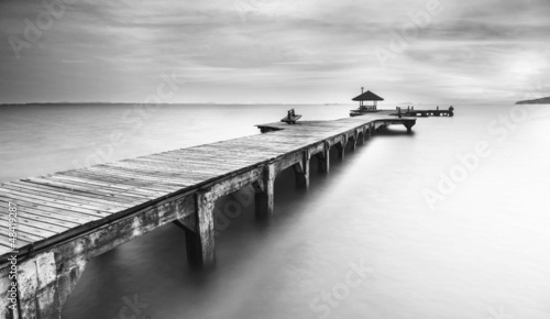 Fototapeta na wymiar Czarno-biały drewniany most nad zatoką