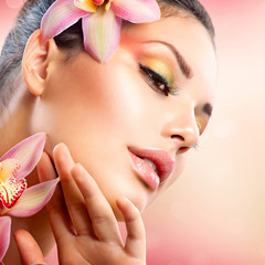 Wall Mural - beautiful spa girl with orchid flowers touching her face