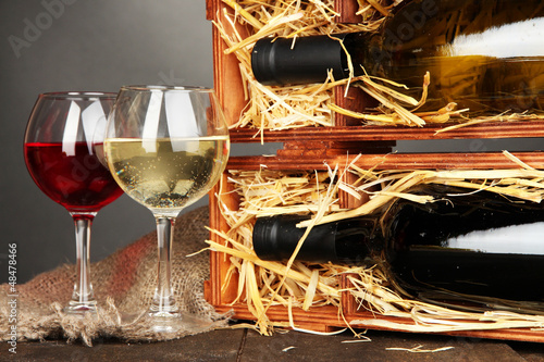 Fototapeta do kuchni Wooden case with wine bottles and wineglasses on grey