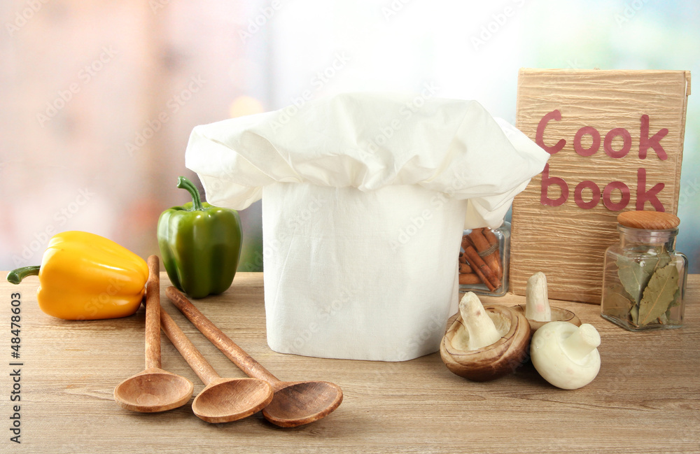 Chef's hat with spoons on table in kitchen
