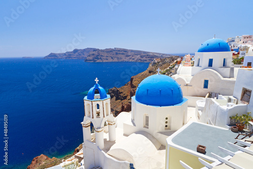 Plakat na papierze fotorealistycznym Błękitny i biały kościół Oia wioska na santorini wyspie. 