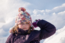 Girl Sitting In Snow Throwing Snowball