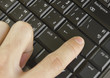 Finger pushing the button of keyboard computer