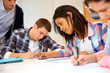 © goodluz - Group of teenagers in class writing an exam