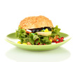 © Africa Studio - Hamburger bun with lettuce and colorful pills on green plate, unhealthy eating and medication overuse