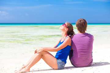 Wall Mural - beautiful young couple sitting and having fun on beach