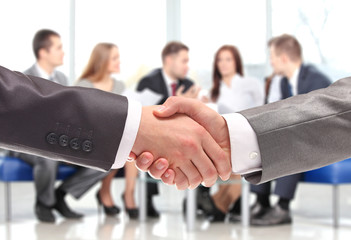 Closeup of business people shaking hands over a deal