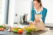 © CandyBox Images - Happy woman making salad kitchen vegetables cooking