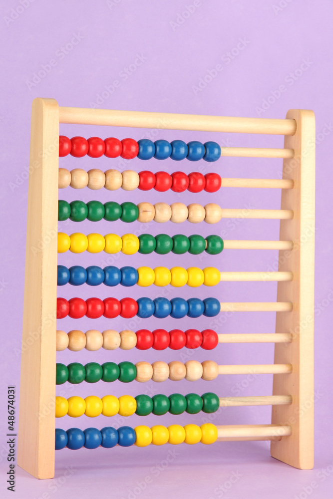 Bright wooden toy abacus, on purple background