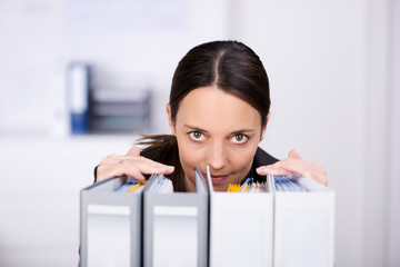 Poster - frau im büro schaut über aktenordner