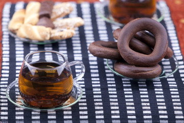 Two cups of tea with two plates with cookies