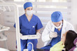 © AntonioDiaz - Dentist and assistant cleaning a patient's teeth