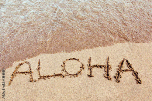 Board z aluminiowym obramowaniem Aloha napisana na hawajskiej plaży