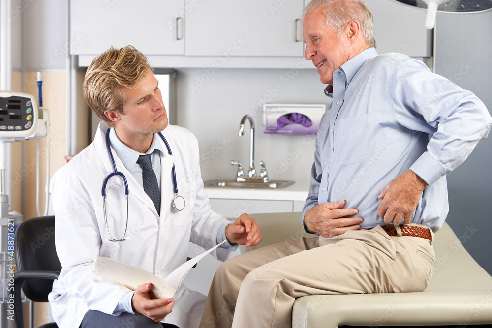 Doctor Examining Male Patient With Hip Pain - obrazy, fototapety, plakaty 