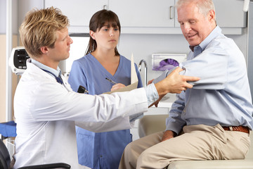 Wall Mural - Doctor Examining Male Patient With Elbow Pain