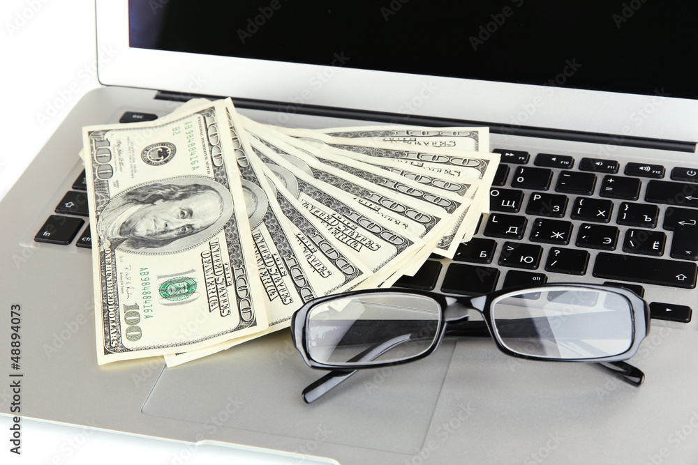 Money with glasses on laptop close-up