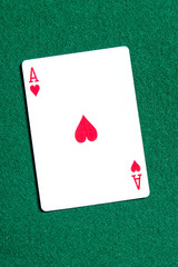 Ace of hearts playing card on the green table