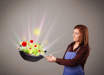 Wall Mural - Young woman cooking fresh vegetables