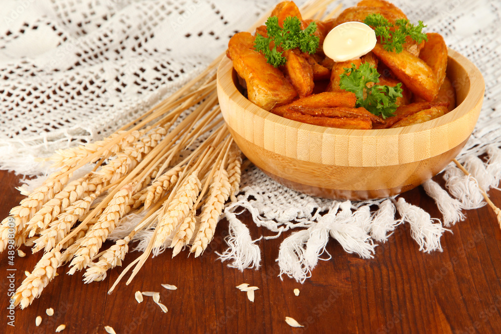 Appetizing village potatoes in bowl on wooden table close-up