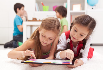 Little girls playing on a tablet computing device