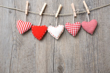 Red Hearts Hanging Over Wood Background