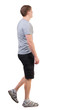 © ghoststone - Back view of walking handsome man in shorts and sneakers.