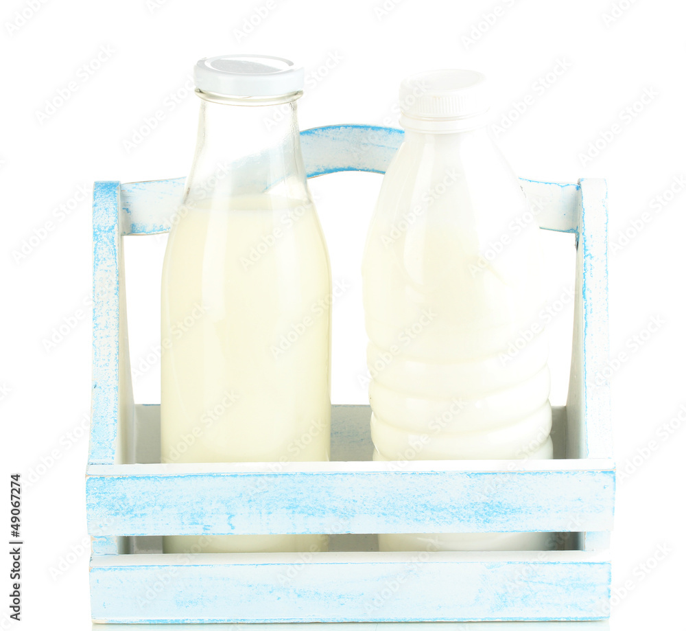 Milk in bottles in wooden box isolated on white