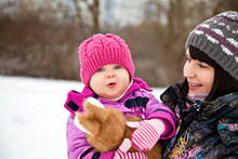 Happy Child In Winter With Her Mother