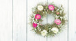 Summer flower wreath on white wooden background