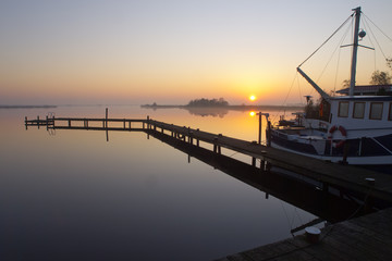 Canvas Print - Fishing boat along a jetty