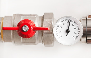 Water thermometer with red valve and metal pipes